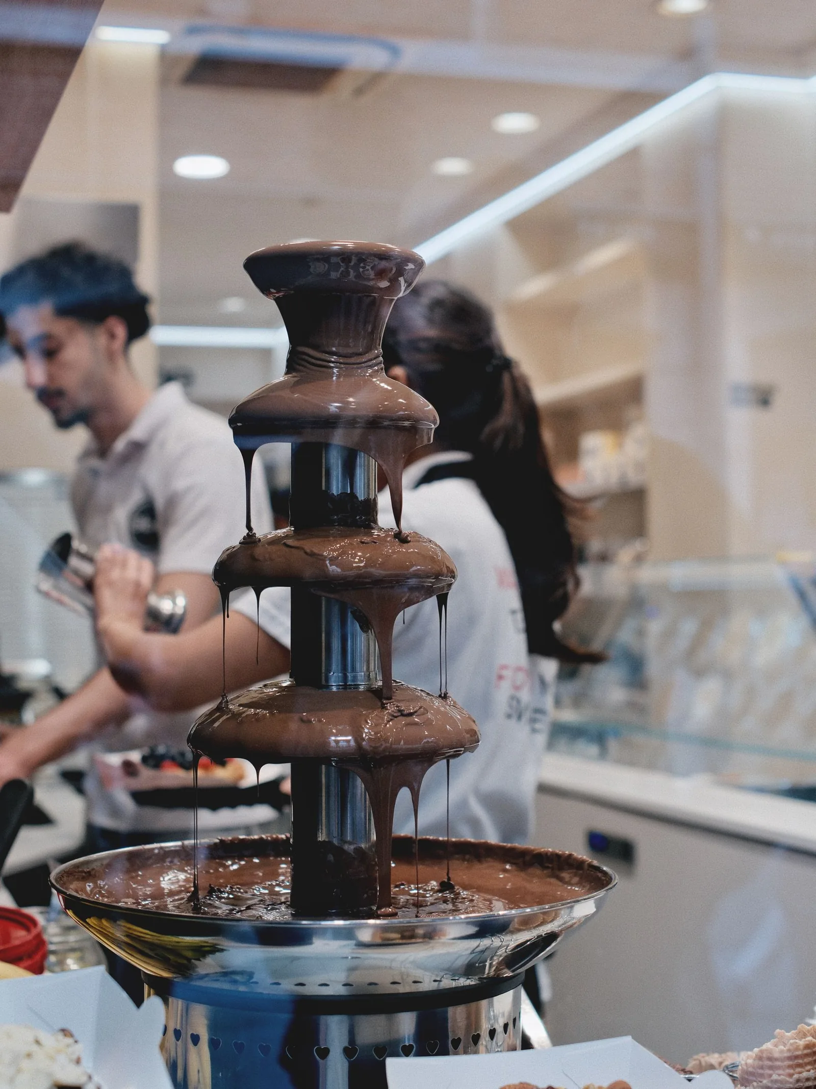 A flowing chocolate fountain at an ice-cream bar